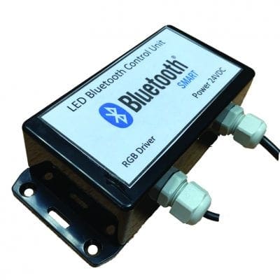 Small rectangular black LED Bluetooth control unit labeled "LED Bluetooth Control Unit Bluetooth SMART RGB Driver Power: 24VDC" sits mounted with two cable glands and wires on a white background.