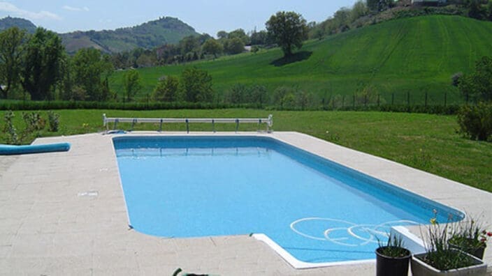 Rectangular outdoor swimming pool with tiled patio